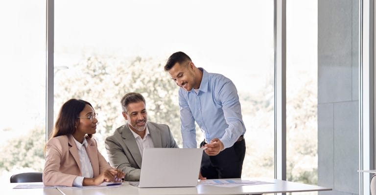 Happy business people executive team working at laptop at office meeting.